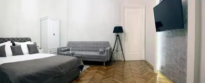 a bedroom with a bed and a couch and a tv at Natalie's Residence in Belgrade
