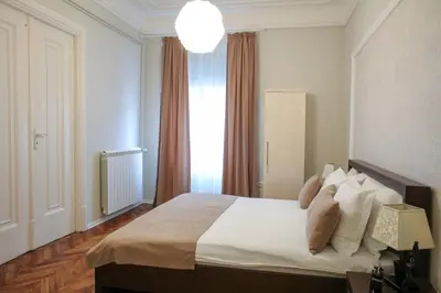 a bedroom with a bed with white sheets and pillows at Natalie's Residence in Belgrade