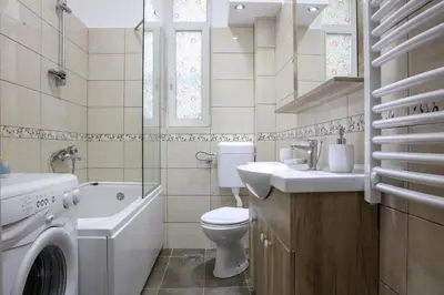 a bathroom with a toilet sink and a washing machine at Natalie's Residence in Belgrade