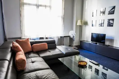 a living room with a leather couch and a glass table at Hearth of Belgrade apartment in Belgrade
