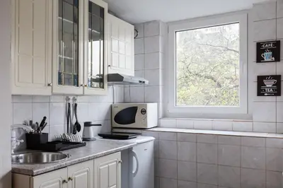 a white kitchen with a sink and a window at Cherry Apartment Arena in Belgrade
