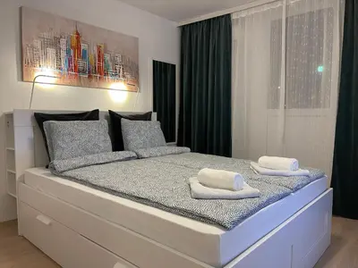a bedroom with a large white bed with towels on it at Cherry Apartment Arena in Belgrade