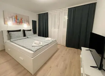 a bedroom with a bed and a flat screen tv at Cherry Apartment Arena in Belgrade