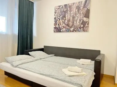 a bedroom with a bed with two towels on it at Cherry Apartment Arena in Belgrade