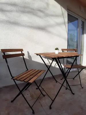 a picnic table and a chair next to a window at Apartment Teodora in Belgrade