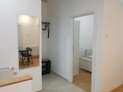 a hallway with a mirror and a room with a table at Apartment Teodora in Belgrade