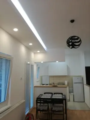a kitchen with a table and two stools in it at Apartment Teodora in Belgrade