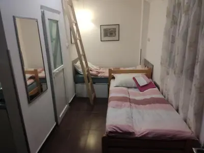 a small bedroom with a bunk bed and a mirror at Green point Apartments in Dušanovac (historical)