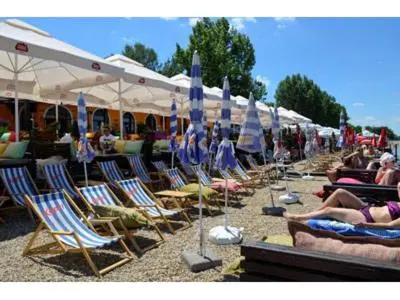 a group of lawn chairs and umbrellas on a beach at Monia Dream Apartment - Belgrade Lake & Fair in Belgrade