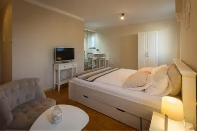 a bedroom with a bed and a tv and a couch at Atelje Knez Mihailova in Belgrade