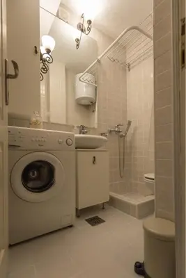 a bathroom with a washing machine and a sink at Atelje Knez Mihailova in Belgrade