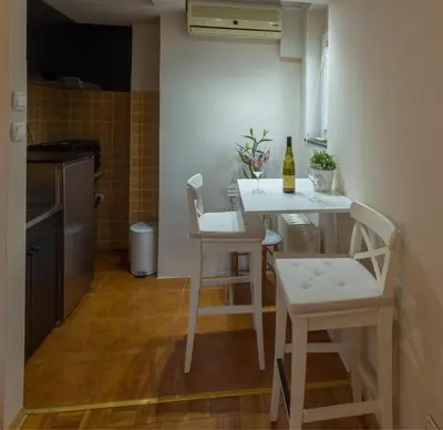 a small kitchen with a table and chairs in a kitchen at Atelje Knez Mihailova in Belgrade