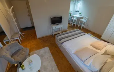 a bedroom with a bed and a table and a tv at Atelje Knez Mihailova in Belgrade
