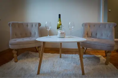 a table with two chairs and a bottle of wine at Atelje Knez Mihailova in Belgrade