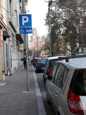 a parking sign on the side of a street with parked cars at Apartment Paradise SunShine in Belgrade
