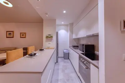 a kitchen with white cabinets and a counter top at Queen Apartments Belgrade Waterfront in Belgrade