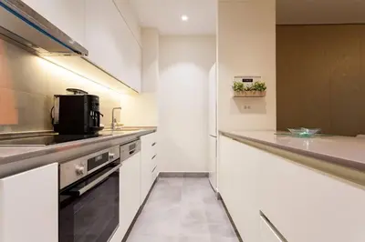 a kitchen with white cabinets and a stove at Queen Apartments Belgrade Waterfront in Belgrade