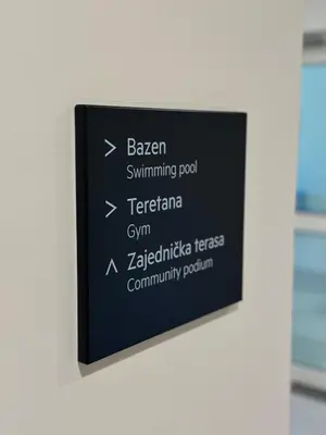 a black sign on a wall with words on it at Queen Apartments Belgrade Waterfront in Belgrade