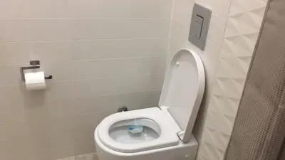 a bathroom with a toilet with the seat up at Cricket Park Hostel in Belgrade