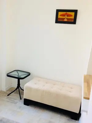 a white couch and a table in a room at Cricket Park Hostel in Belgrade