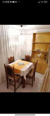 a dining room with a table and chairs and a shelf at Apartments Forest in Belgrade
