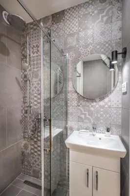 a bathroom with a shower with a sink and a mirror at Delights Apartment Belgrade in Belgrade