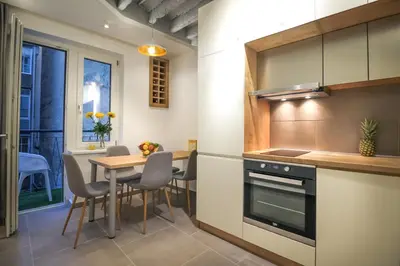 a kitchen with a table and a dining room at Delights Apartment Belgrade in Belgrade