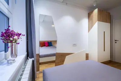 a small bedroom with a bed and a window at Delights Apartment Belgrade in Belgrade
