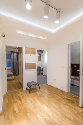 an empty room with white walls and wood floors at Delights Apartment Belgrade in Belgrade