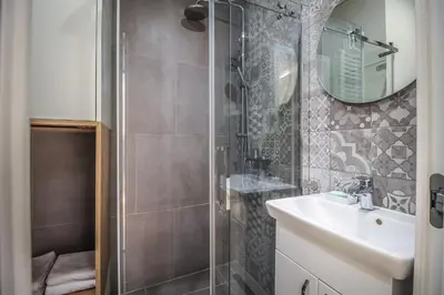 a bathroom with a shower and a sink and a mirror at Delights Apartment Belgrade in Belgrade