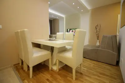 a dining room with a white table and chairs at Luna Lux Apartman in Belgrade