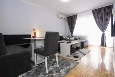 a living room with a table and a couch at Cezar Apartment in Belgrade