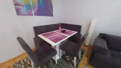 a dining room table and chairs with a candle on it at Cezar Apartment in Belgrade