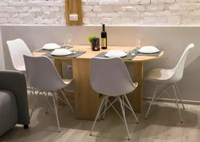 a table with white chairs and a bottle of wine at Brigitte's Central in Belgrade
