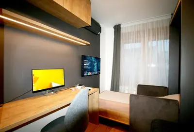 a room with a desk with a television and a window at Apartment Gotham in Belgrade