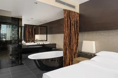 a bathroom with a tub and a sink and a bed at Zijin Hotel Belgrade in Belgrade