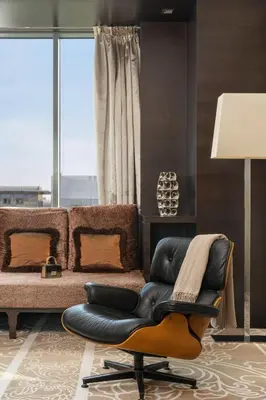 a living room with a chair and a bed at Zijin Hotel Belgrade in Belgrade