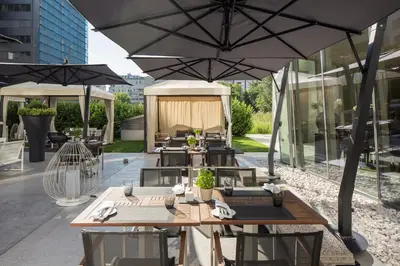 an outdoor patio with tables and umbrellas at Zijin Hotel Belgrade in Belgrade