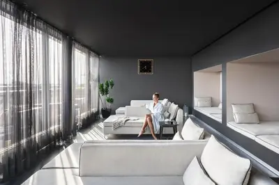 a man sitting on a couch in a living room at Zijin Hotel Belgrade in Belgrade