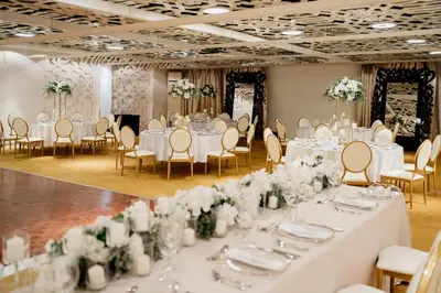 a wedding banquet room with white tables and chairs at Zijin Hotel Belgrade in Belgrade