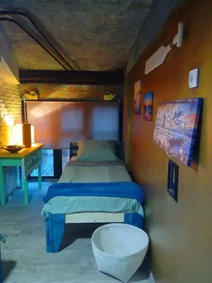 a small bed in a room with a table at NapPARK Hostel in Belgrade