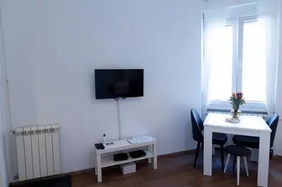 a small room with a table and a tv on the wall at DOWNTOWN STUDIO AP in Belgrade