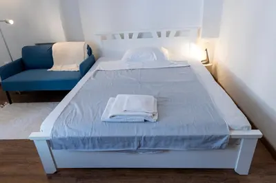 a bed and a blue chair in a room at DOWNTOWN STUDIO AP in Belgrade