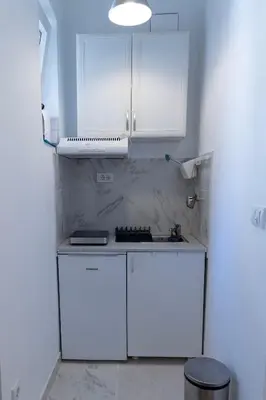 a white kitchen with white cabinets and a stove at DOWNTOWN STUDIO AP in Belgrade