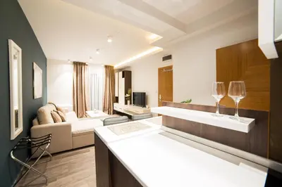a kitchen and living room with two wine glasses on a counter at Belgrade Center Luxury Apartments in Belgrade
