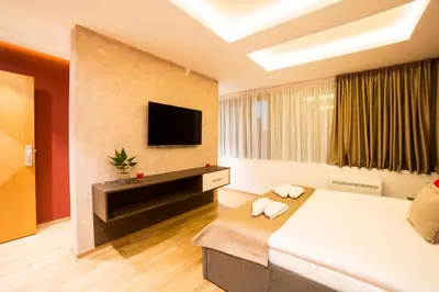 a hotel room with a bed and a flat screen tv at Belgrade Center Luxury Apartments in Belgrade