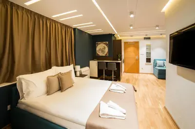 a bedroom with a large bed and a living room at Belgrade Center Luxury Apartments in Belgrade
