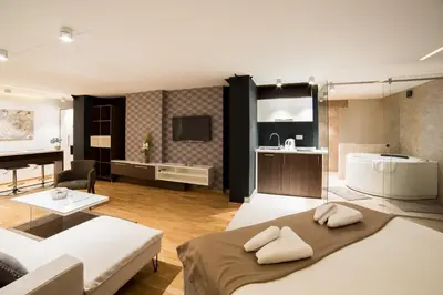 a living room with a bed and a couch and a kitchen at Belgrade Center Luxury Apartments in Belgrade