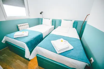 two beds in a small room with towels on them at Lola Almost Home in Belgrade