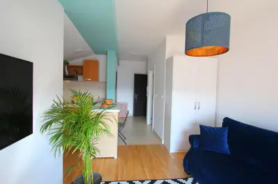 a living room with a blue couch and a plant at Lola Almost Home in Belgrade